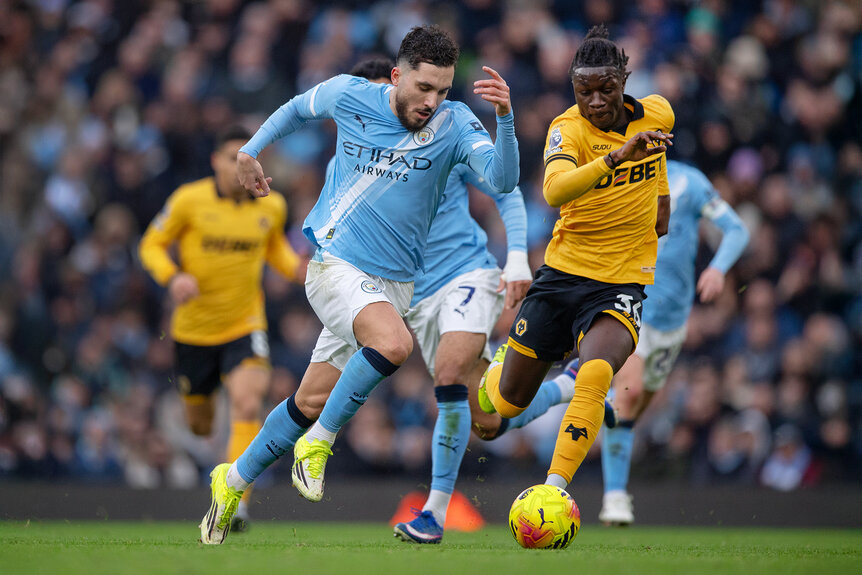 Rayan Cherki of Manchester City and Mateus Mane of Wolverhampton Wanderers running with the ball during the Premier League match between Manchester City and Wolverhampton Wanderers.