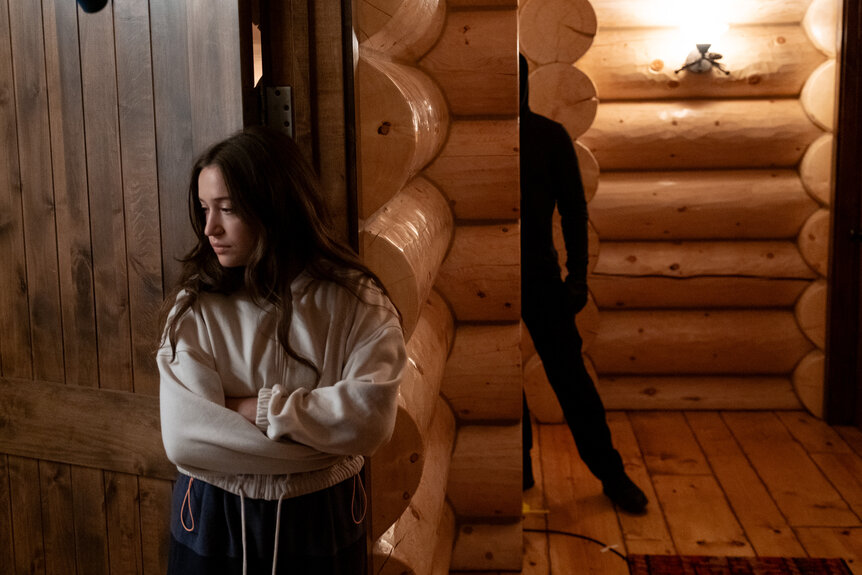 A dark figure hides behind a wall near Parker Mason (Gideon Adlon) in Sick (2022).